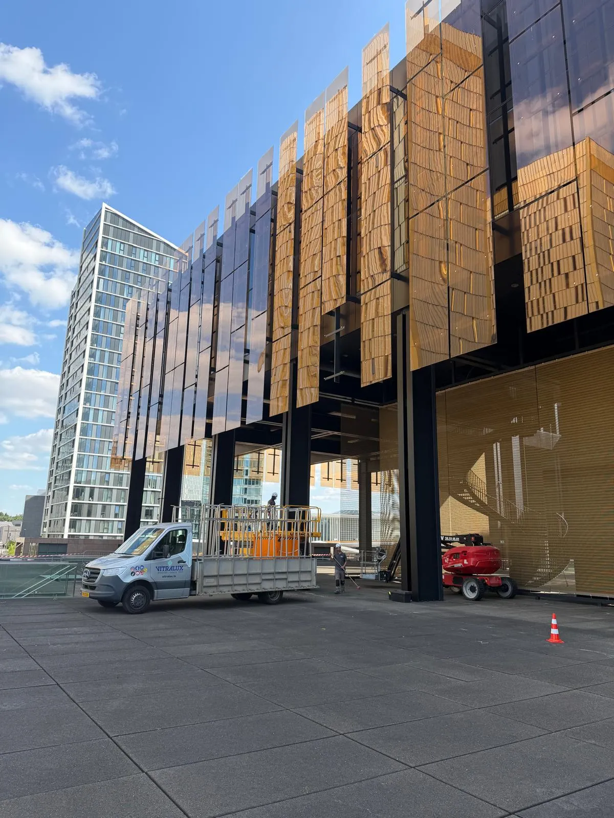 Camion et nacelle Vitralux devant une façade vitrée en chantier au Luxembourg — Vitralux Bradtke
